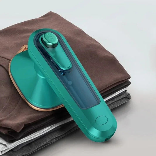 Portable Mini Steam Iron on a stack of folded clothes with a white background