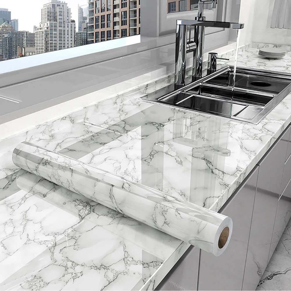 Marble-patterned roll of marble shhet on a kitchen counter with a cityscape view.