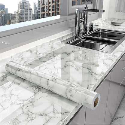 Marble-patterned roll of marble shhet on a kitchen counter with a cityscape view.