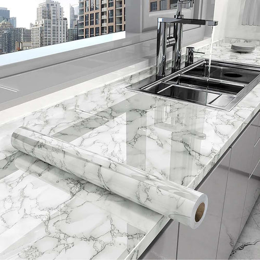 Marble-patterned roll of marble shhet on a kitchen counter with a cityscape view.