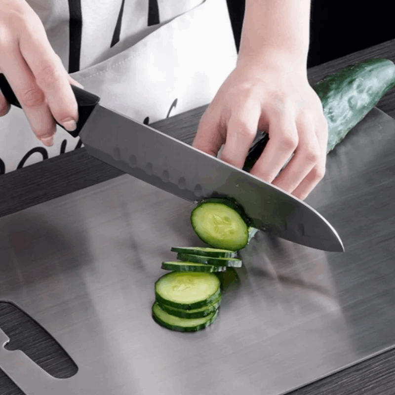 Person slicing cucumbers on a cutting board with a knife