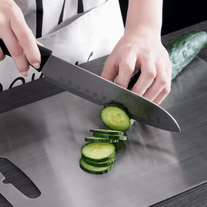 Person slicing cucumbers on a cutting board with a knife